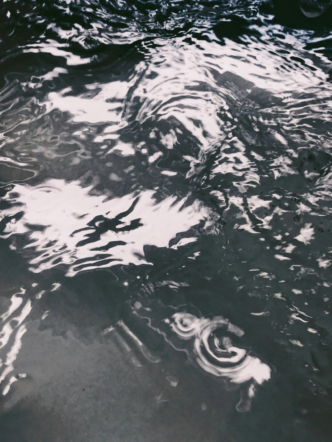a black and white photo of water and clouds