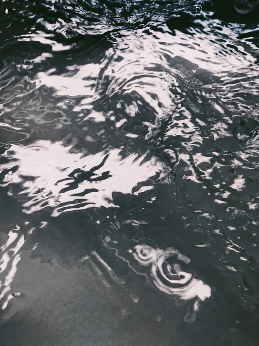 a black and white photo of water and clouds